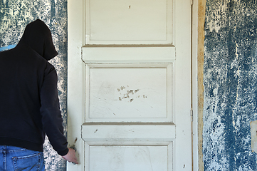 Image showing man opening door of decayed room