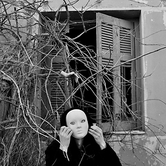 Image showing masked figure and overgrown plants