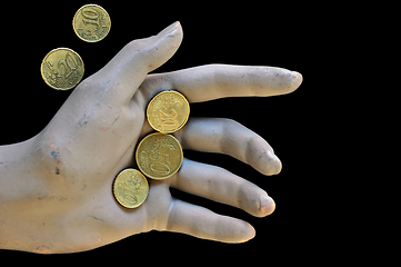 Image showing worn doll hand holding euro coins