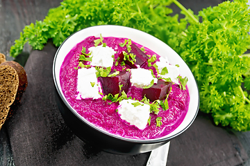 Image showing Soup puree of beetroot with salted cheese in bowl on board