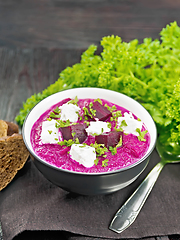 Image showing Soup puree of beetroot with salted cheese in bowl on napkin