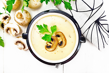 Image showing Soup puree of champignon in bowl on board top