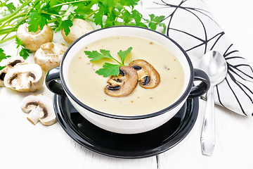 Image showing Soup puree of champignon in bowl on board