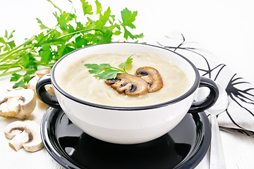 Image showing Soup puree of champignon in bowl on white board