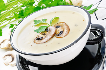 Image showing Soup puree of champignon in bowl on wooden board