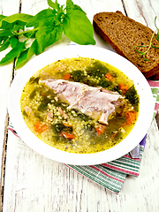 Image showing Soup with couscous and spinach in plate on board