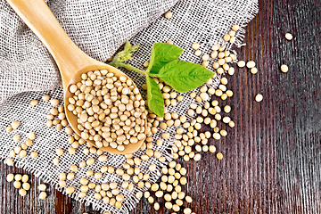 Image showing Soybeans in spoon with leaf on dark board top