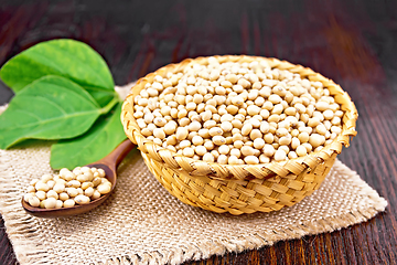 Image showing Soybeans in wicker bowl with leaf on wooden board