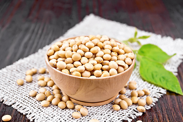 Image showing Soybeans in wooden bowl with leaf on dark board