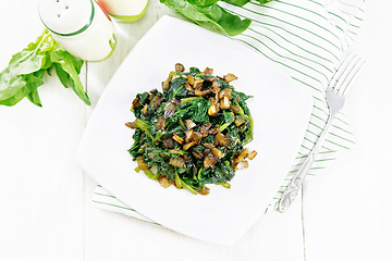 Image showing Spinach fried with onions in plate on board top