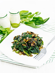 Image showing Spinach fried with onions in plate on napkin