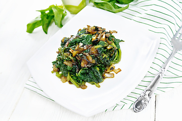 Image showing Spinach fried with onions in plate on white board