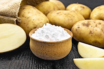 Image showing Starch potato in bowl on dark board