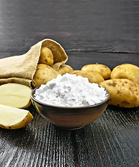 Image showing Starch potato in clay bowl on dark board