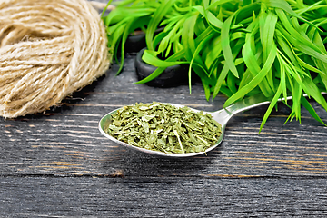 Image showing Tarragon dried in spoon on dark board