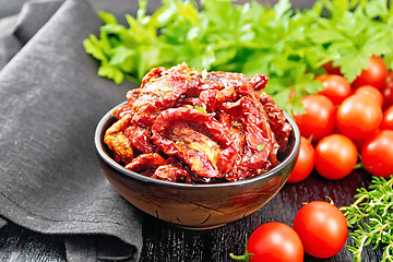 Image showing Tomatoes sun-dried in bowl with napkin on board