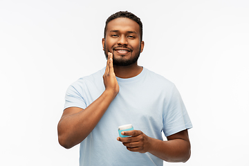 Image showing happy african man applying wax to his beard