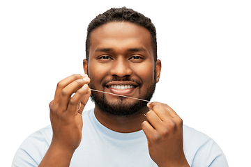 Image showing happy african man with dental floss cleaning teeth