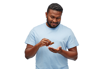 Image showing african man applying grooming oil to beard