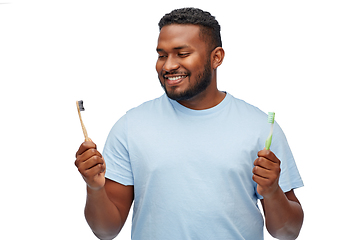 Image showing african man with wooden and plastic toothbrushes