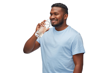 Image showing happy african man drinking water from glass bottle