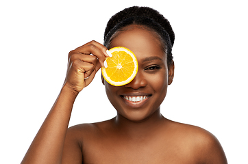 Image showing smiling african woman making eye mask of oranges