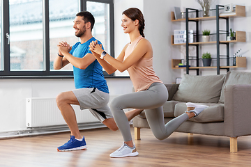 Image showing couple exercising and doing lunge at home