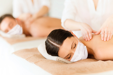 Image showing couple in masks having back massage at spa