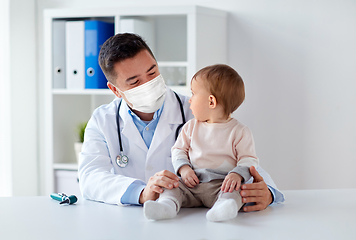 Image showing doctor or pediatrician in mask with baby at clinic