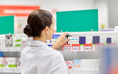 Image showing female pharmacist with medicine at pharmacy