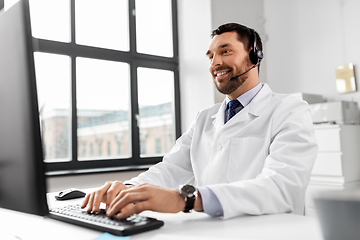 Image showing happy doctor with computer and headset at hospital