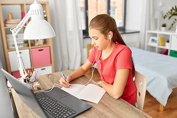 Image showing student girl in earphones learning at home