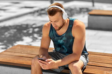 Image showing young athlete man with headphones and smartphone