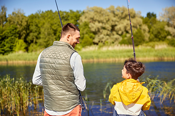 Image showing happy smiling father and son fishing on river