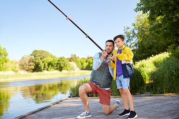 Image showing happy smiling father and son fishing on river