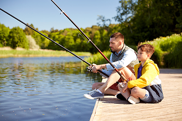 Image showing happy smiling father and son fishing on river