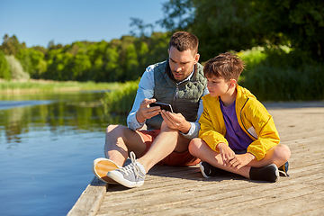 Image showing father and son with smartphone on river berth