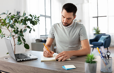 Image showing man with notebook and laptop at home office