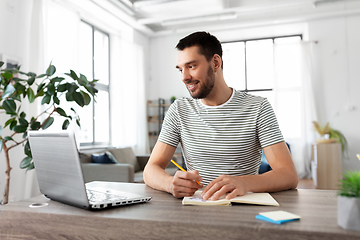 Image showing man with notebook and laptop at home office