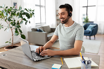 Image showing man with headset and laptop working at home