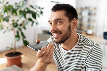 Image showing man calling or recording voice with phone at home