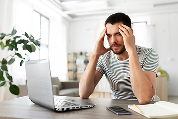 Image showing stressed man with laptop working at home office