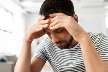 Image showing close up of stressed man having headache at home