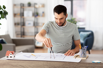 Image showing architect with blueprint working at home office