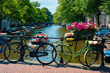 Image showing Amsterdam canal with boats and bicycles on a bridge