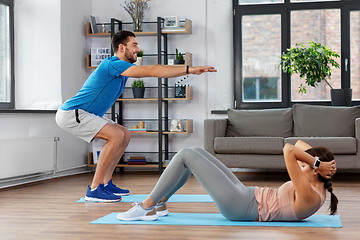 Image showing happy young man and woman exercising at home