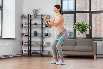 Image showing woman exercising with resistance band at home