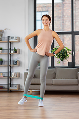 Image showing woman exercising with resistance band at home