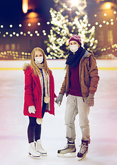 Image showing couple in masks holding hands on skating rink