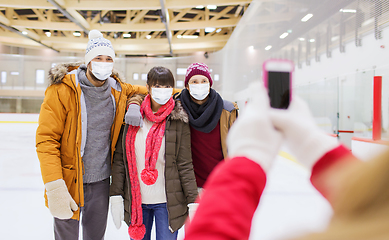 Image showing friends in masks taking photo on skating rink